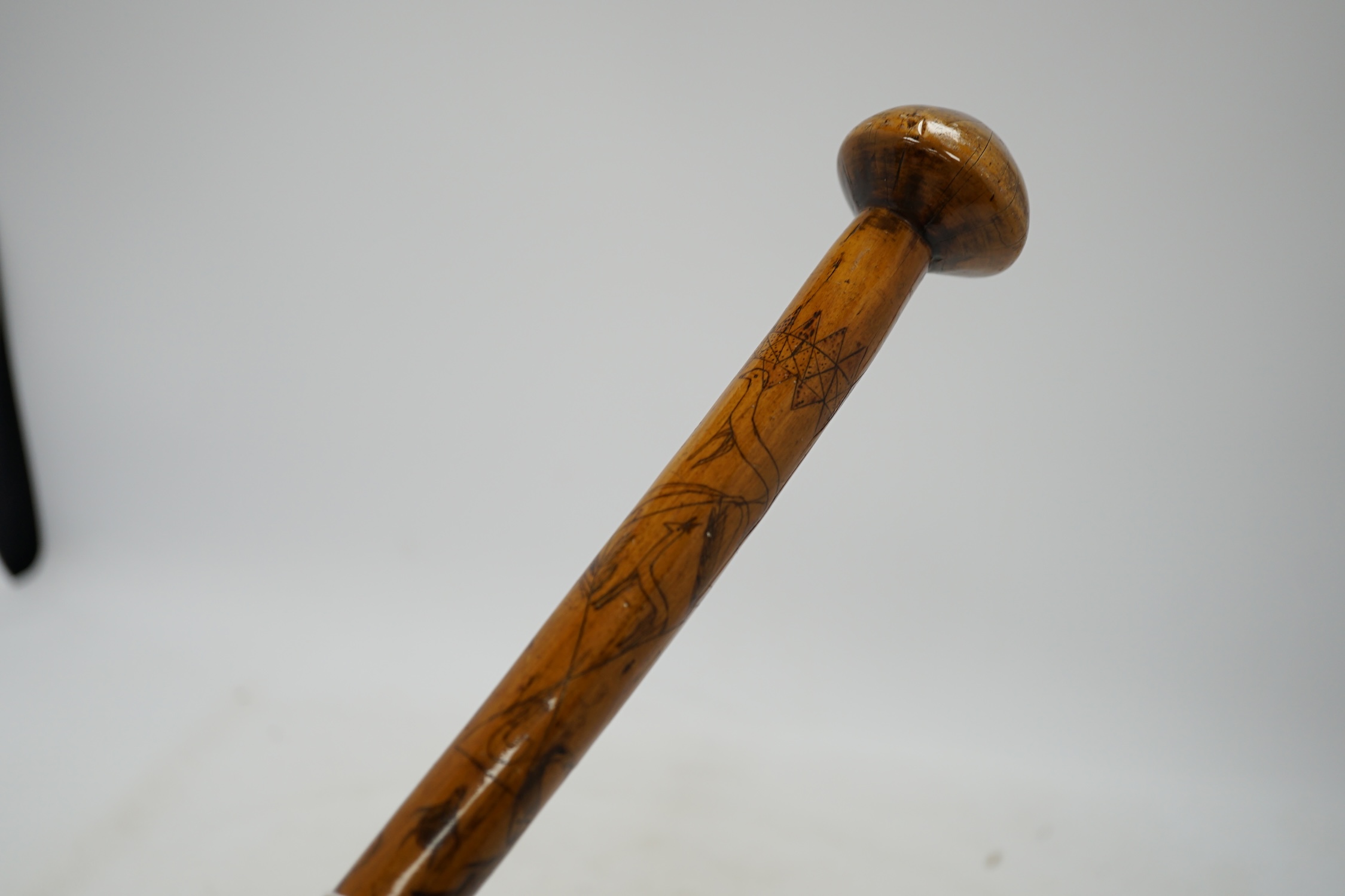 An aboriginal walking stick, inscribed Alice Adelaide, Queenstown, with primitively incised animal and bird imagery, 96cm long. Condition - crack to knob/handle and bottom section worn, central section with incised image